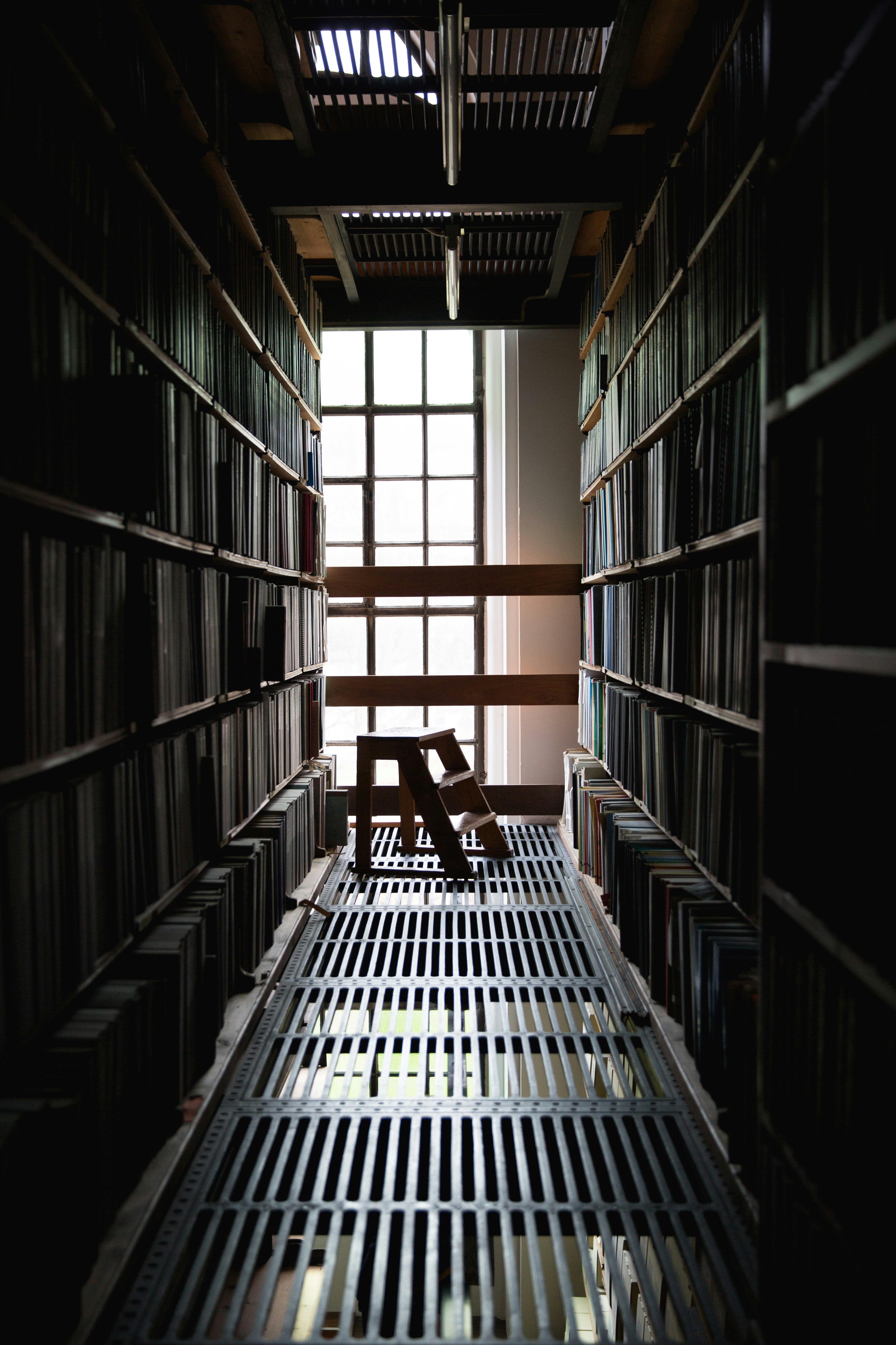 brown wooden mini stair in between of book shelves